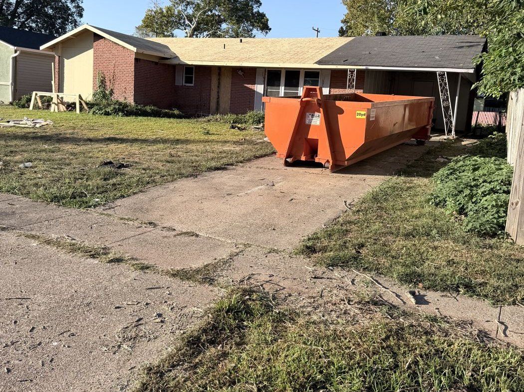 Orange Bossier Dumpster Rental container placed in a residential driveway for a clean-out