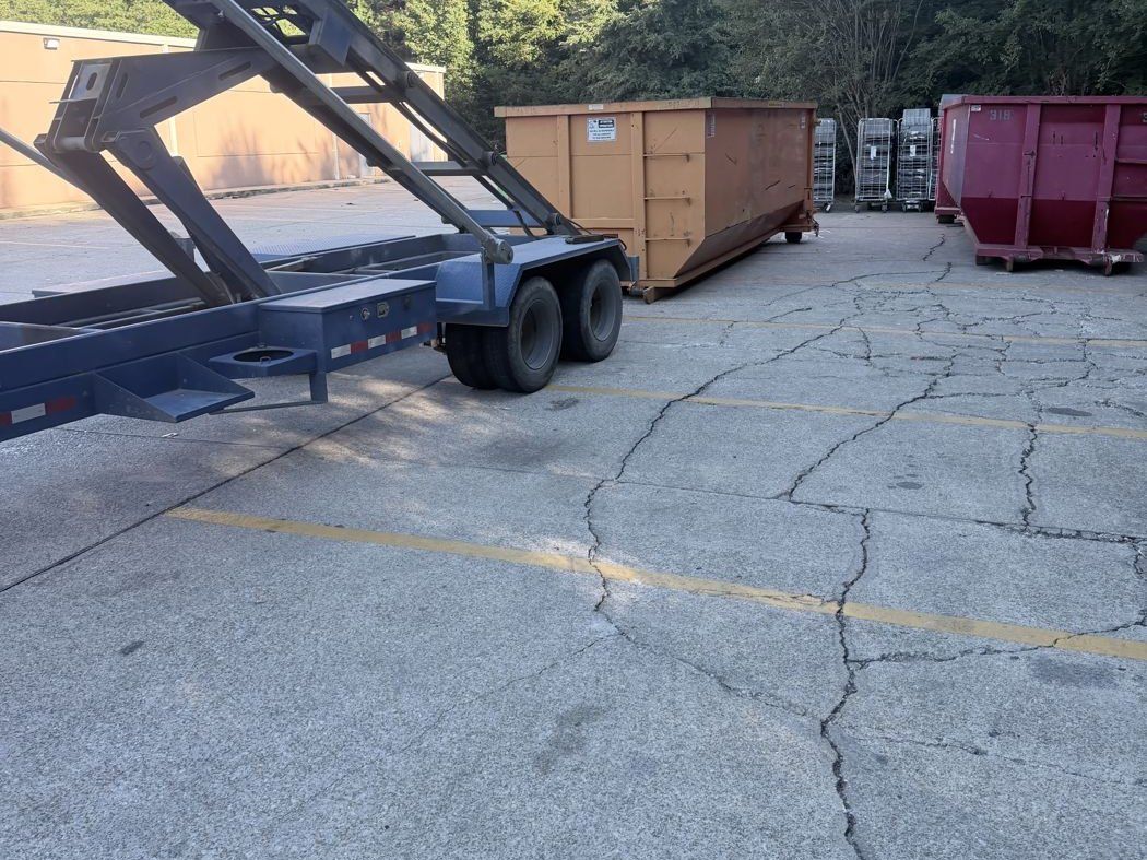 Orange and red roll-off containers staged on a trailer at the yard