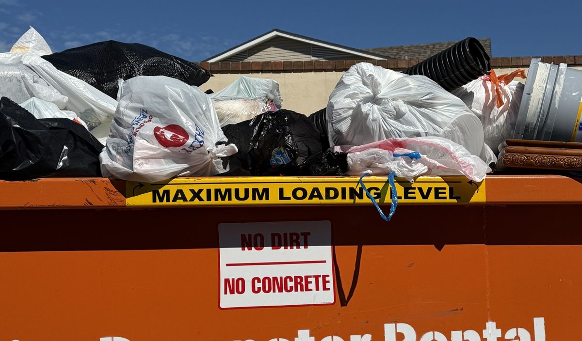 Maximum loading level line and no dirt, no concrete label on a Bossier Dumpster Rental container