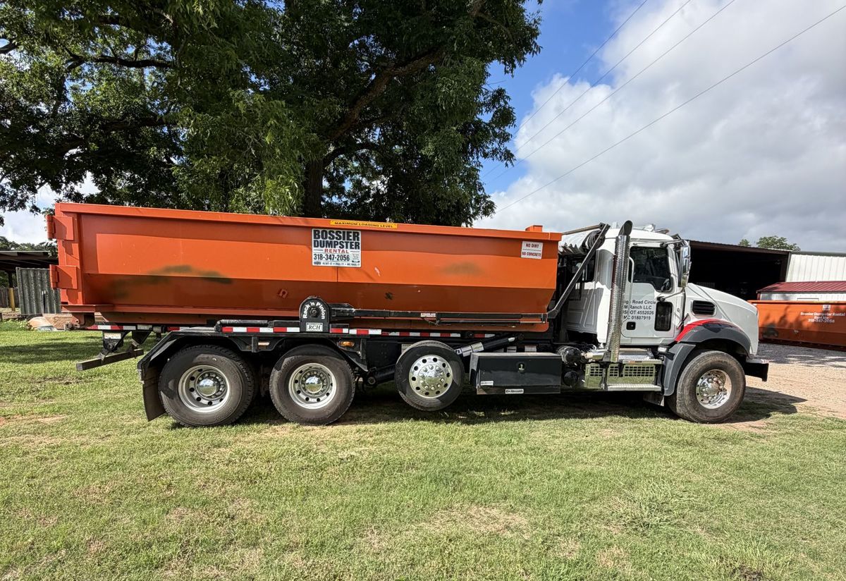 Bossier Dumpster Rental Mack roll-off truck carrying an orange 30-yard dumpster